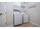 Convenient laundry room with white front-load washer and dryer, plus upper cabinets for storage at 16913 Clear Cork Dr, Wimauma, FL 33598
