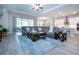 Spacious living area with stylish furniture, tile flooring, and natural light from large windows at 16913 Clear Cork Dr, Wimauma, FL 33598