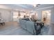 Bright, open-concept space featuring a comfortable gray sofa and well-equipped white kitchen, great for families at 16913 Clear Cork Dr, Wimauma, FL 33598
