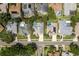 An aerial view showcases neighborhood homes, many with pools and well-manicured lawns and mature trees at 1793 Pipers Meadow Dr, Palm Harbor, FL 34683
