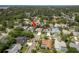 An aerial view highlights a charming home nestled among lush trees in a well-established neighborhood at 1793 Pipers Meadow Dr, Palm Harbor, FL 34683