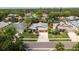 Aerial view of a well-manicured home in a suburban neighborhood with mature trees and lush landscaping at 1793 Pipers Meadow Dr, Palm Harbor, FL 34683