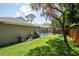 This spacious backyard features a screened-in pool enclosure, well-maintained lawn, and mature landscaping at 1793 Pipers Meadow Dr, Palm Harbor, FL 34683
