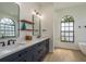 Stylish bathroom features a double vanity with quartz countertops, dark blue cabinets and modern fixtures and lighting at 1793 Pipers Meadow Dr, Palm Harbor, FL 34683