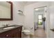 Hall bathroom featuring dark vanity, toilet, and view into laundry room at 1793 Pipers Meadow Dr, Palm Harbor, FL 34683