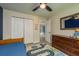 Bedroom features a road-themed rug, ceiling fan, closet, and open door, offering ample storage and accessibility at 1793 Pipers Meadow Dr, Palm Harbor, FL 34683