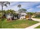 Charming single-story home with a manicured front lawn, mature palm trees, and an attached two-car garage at 1793 Pipers Meadow Dr, Palm Harbor, FL 34683