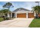 Beautiful home with a three-car garage, well-kept lawn, and mature trees providing shade at 1793 Pipers Meadow Dr, Palm Harbor, FL 34683