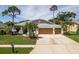 Well-maintained single-Gathering home with a spacious driveway, a three-car garage, and a landscaped front yard at 1793 Pipers Meadow Dr, Palm Harbor, FL 34683