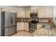 Well-equipped kitchen featuring stainless steel appliances, granite countertops, and ample cabinet space for modern convenience at 1793 Pipers Meadow Dr, Palm Harbor, FL 34683