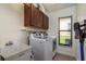 Bright laundry room featuring a utility sink, cabinets and washer/dryer at 1793 Pipers Meadow Dr, Palm Harbor, FL 34683