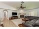 Inviting living room features a fireplace, plush seating, and a modern ceiling fan at 1793 Pipers Meadow Dr, Palm Harbor, FL 34683
