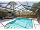 Screened in pool and spa featuring outdoor living and dining area with ceiling fans at 1793 Pipers Meadow Dr, Palm Harbor, FL 34683