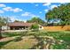 Large backyard with a covered patio area, stone seating, and mature shade trees at 1807 Tawnee Pl, Brandon, FL 33510