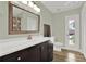 Well-lit bathroom features a modern vanity with a white countertop and a framed mirror at 1807 Tawnee Pl, Brandon, FL 33510