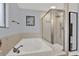 Bright bathroom featuring a soaking tub and a glass-enclosed shower with neutral tile at 1807 Tawnee Pl, Brandon, FL 33510