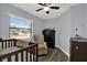 Cozy Bedroom with a crib, a changing table, and a ceiling fan with hardwood floors at 1807 Tawnee Pl, Brandon, FL 33510