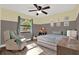 Cozy bedroom featuring a ceiling fan, wood-look flooring, comfortable chair, and lots of natural light at 1807 Tawnee Pl, Brandon, FL 33510