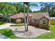 Charming brick home with well-manicured landscaping, decorative stone, mature trees, and inviting curb appeal at 1807 Tawnee Pl, Brandon, FL 33510