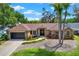 Charming brick home boasts an inviting entrance, well-maintained lawn, and a two-car garage for convenience at 1807 Tawnee Pl, Brandon, FL 33510