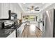 Modern kitchen with white cabinets, stainless steel appliances, granite countertops, and hardwood flooring at 1807 Tawnee Pl, Brandon, FL 33510