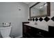 Classic bathroom featuring a dark wood vanity with a marble countertop, decorative mirror and fixtures at 1836 Bough Ave # C, Clearwater, FL 33760