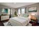 Bright bedroom featuring a cozy bed, stylish decor, natural light, and wooden accents at 1836 Bough Ave # C, Clearwater, FL 33760