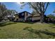 Exterior side view of a well maintained home with a spacious lawn area shaded by a large tree at 1836 Bough Ave # C, Clearwater, FL 33760