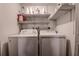 Practical laundry area showcasing a washer and dryer with overhead shelving for storage at 1836 Bough Ave # C, Clearwater, FL 33760
