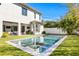 Beautiful backyard with a modern pool, well-maintained lawn, and patio with outdoor kitchen and dining area at 1903 S Cardenas Ave, Tampa, FL 33629