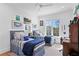 Bright bedroom with two twin beds, hardwood floors, an accent rug, and a workspace with natural light at 1903 S Cardenas Ave, Tampa, FL 33629