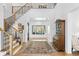 Bright foyer showcasing hardwood floors, a staircase with iron railings, and a clear view to the backyard at 1903 S Cardenas Ave, Tampa, FL 33629