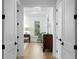 Bright hallway featuring hardwood floors and a glimpse of a sitting room with view outside at 1903 S Cardenas Ave, Tampa, FL 33629