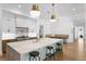 Spacious open kitchen featuring a marble island with stools, stainless steel appliances, and hardwood floors at 1903 S Cardenas Ave, Tampa, FL 33629