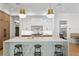 Large kitchen island with stools, and marble countertops with stainless appliances, plus hardwood floors at 1903 S Cardenas Ave, Tampa, FL 33629