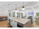 Open kitchen with island and seating that transitions into a living room with fireplace and beamed ceilings at 1903 S Cardenas Ave, Tampa, FL 33629