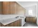 Well-organized laundry room with upper cabinets, marble countertops, modern washer and dryer, and tile flooring at 1903 S Cardenas Ave, Tampa, FL 33629