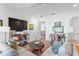 Bright living room featuring hardwood floors, neutral furnishings, a modern TV console, and natural light at 1903 S Cardenas Ave, Tampa, FL 33629