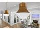 Open-concept living room featuring pendant lighting, hardwood flooring, and a fireplace with a marble surround at 1903 S Cardenas Ave, Tampa, FL 33629