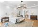 A luxurious main bedroom with decorative chandelier, hardwood floors, and ensuite bathroom entrance at 1903 S Cardenas Ave, Tampa, FL 33629