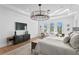 Bright and airy main bedroom suite boasts a modern light fixture and a sitting area at 1903 S Cardenas Ave, Tampa, FL 33629