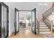 View of the office through the double glass doors, featuring a hardwood staircase with iron railing at 1903 S Cardenas Ave, Tampa, FL 33629