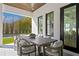 Inviting covered outdoor dining area with wood table, cushioned chairs, and view of the pool and landscape at 1903 S Cardenas Ave, Tampa, FL 33629
