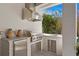 Outdoor kitchen with a stainless steel grill, brick accents, and convenient sink area at 1903 S Cardenas Ave, Tampa, FL 33629