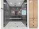 Modern glass shower with dark tile, marble floors, and a convenient bench at 1903 S Cardenas Ave, Tampa, FL 33629