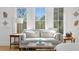 Sitting area with a comfortable couch and windows showcasing a view of lush, green trees at 1903 S Cardenas Ave, Tampa, FL 33629