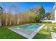 A luxurious backyard features a modern pool, complemented by vibrant greenery and tall bamboo plants for privacy at 1903 S Cardenas Ave, Tampa, FL 33629