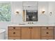Close up of a wooden bathroom vanity with white marble countertops and black hardware at 1903 S Cardenas Ave, Tampa, FL 33629