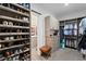 Well-organized walk-in closet with custom shelving, storage, shoe racks, ottoman, and access to another closet at 1903 S Cardenas Ave, Tampa, FL 33629
