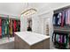 Spacious walk-in closet with custom shelving, storage island, marble countertop, modern chandelier, and ample storage at 1903 S Cardenas Ave, Tampa, FL 33629